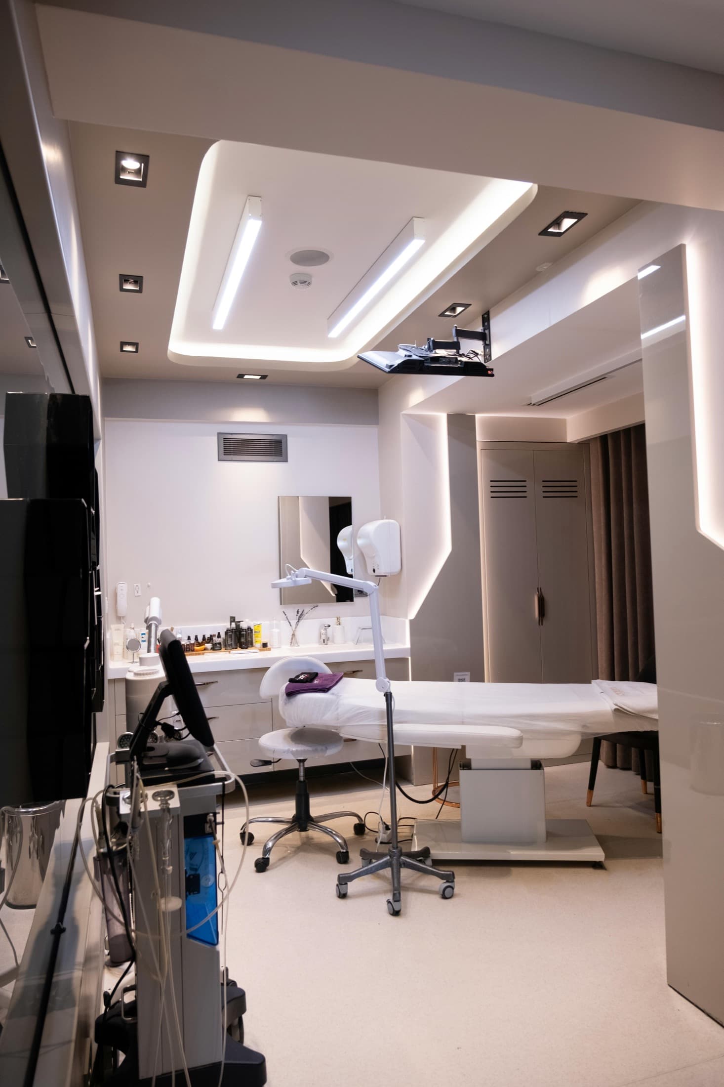 Modern private clinic treatment room with clean lighting and medical equipment.